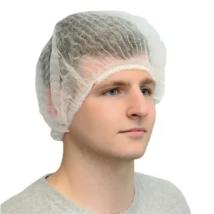 Cleanroom operative wearing a white bouffant cap and a grey t shirt