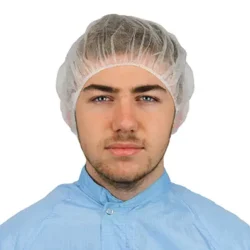 Cleanroom operative wearing a white pleated flat packed bouffant cap and blue permanent coverall