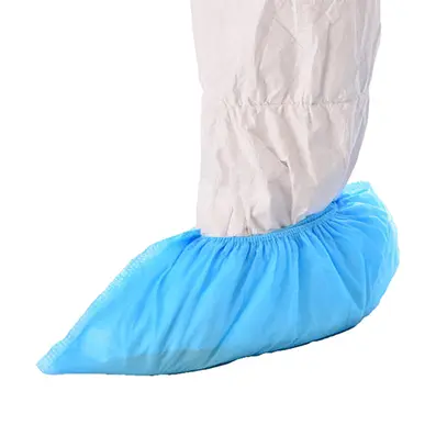 603-4003-Nonwoven-shoe-cover.webp Non woven cleanroom polypropylene shoe cover, blue in colour, being worn on the foot of a cleanroom operative wearing a cleanroom coverall